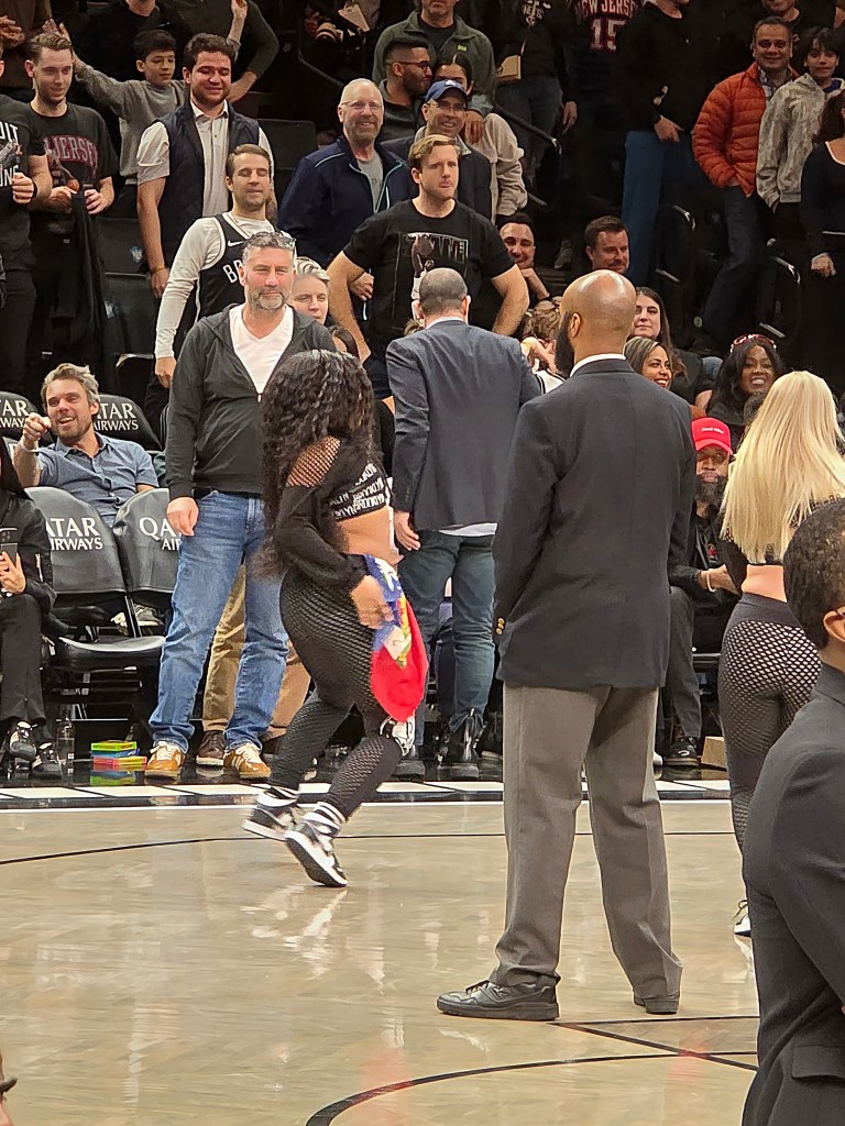 A Brooklynette and dancers with Team Hype wave Haitian flags during the West Indian Carnival-themed night at Barclays Center in Brooklyn on Tuesday, March 10, 2026. Photos by Darlie Gervais for The Haitian Times