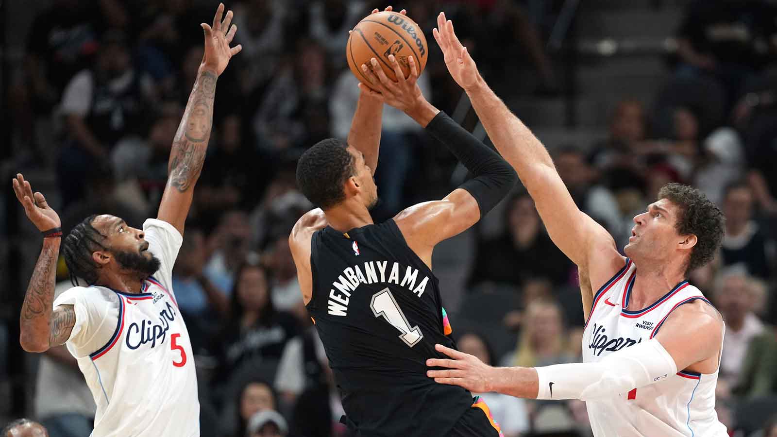 San Antonio Spurs forward Victor Wembanyama (1) shoots while defended by Los Angeles Clippers center Brook Lopez (11) and guard Derrick Jones Jr. (5) during the first half at Frost Bank Center. Mandatory Credit: Scott Wachter-Imagn Images