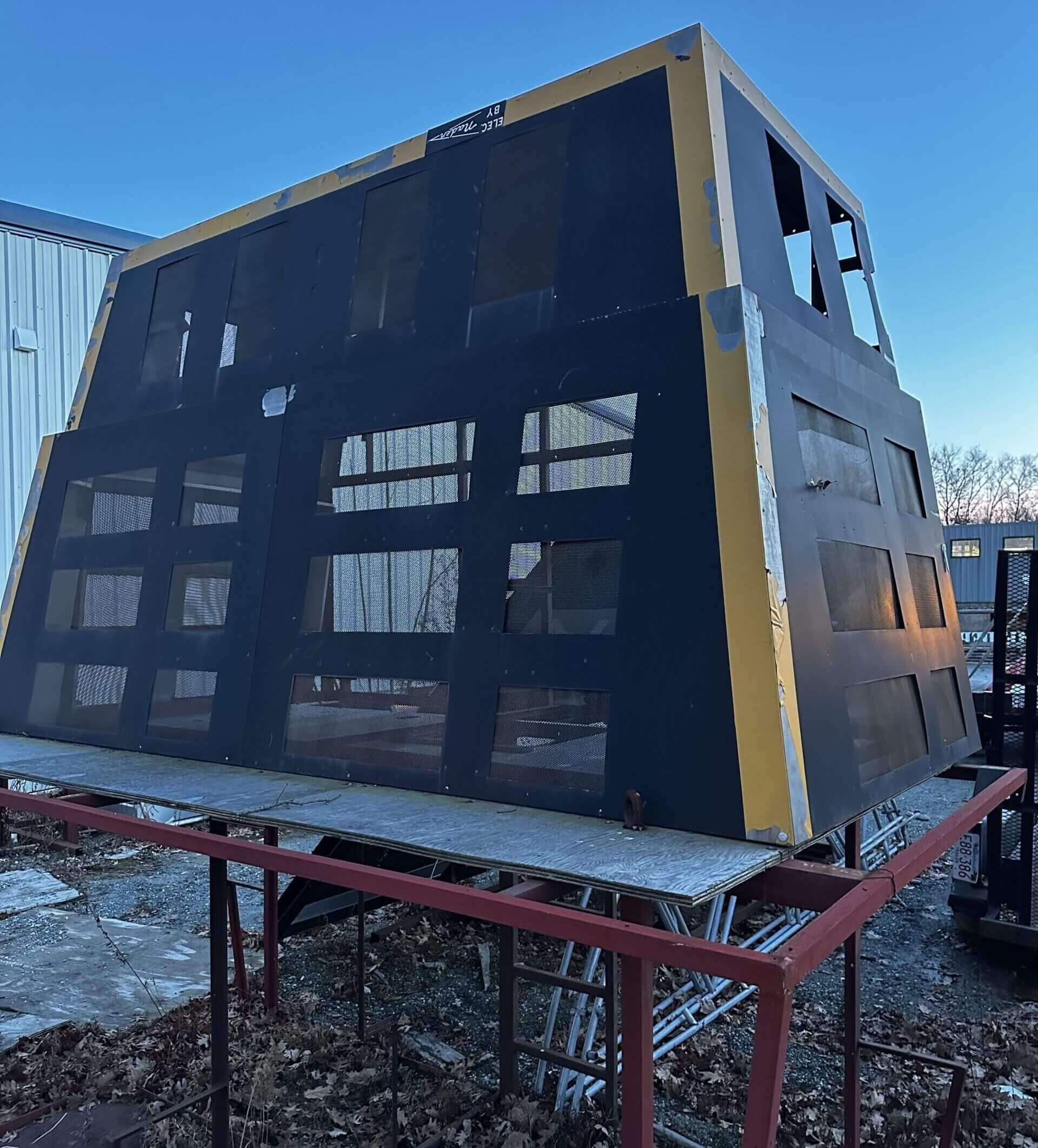 The scoreboard sits upside-down on a platform outside a warehouse south of Boston, with its bulbs, circuits and wiring having been removed. (Courtesy of Ted Tye)