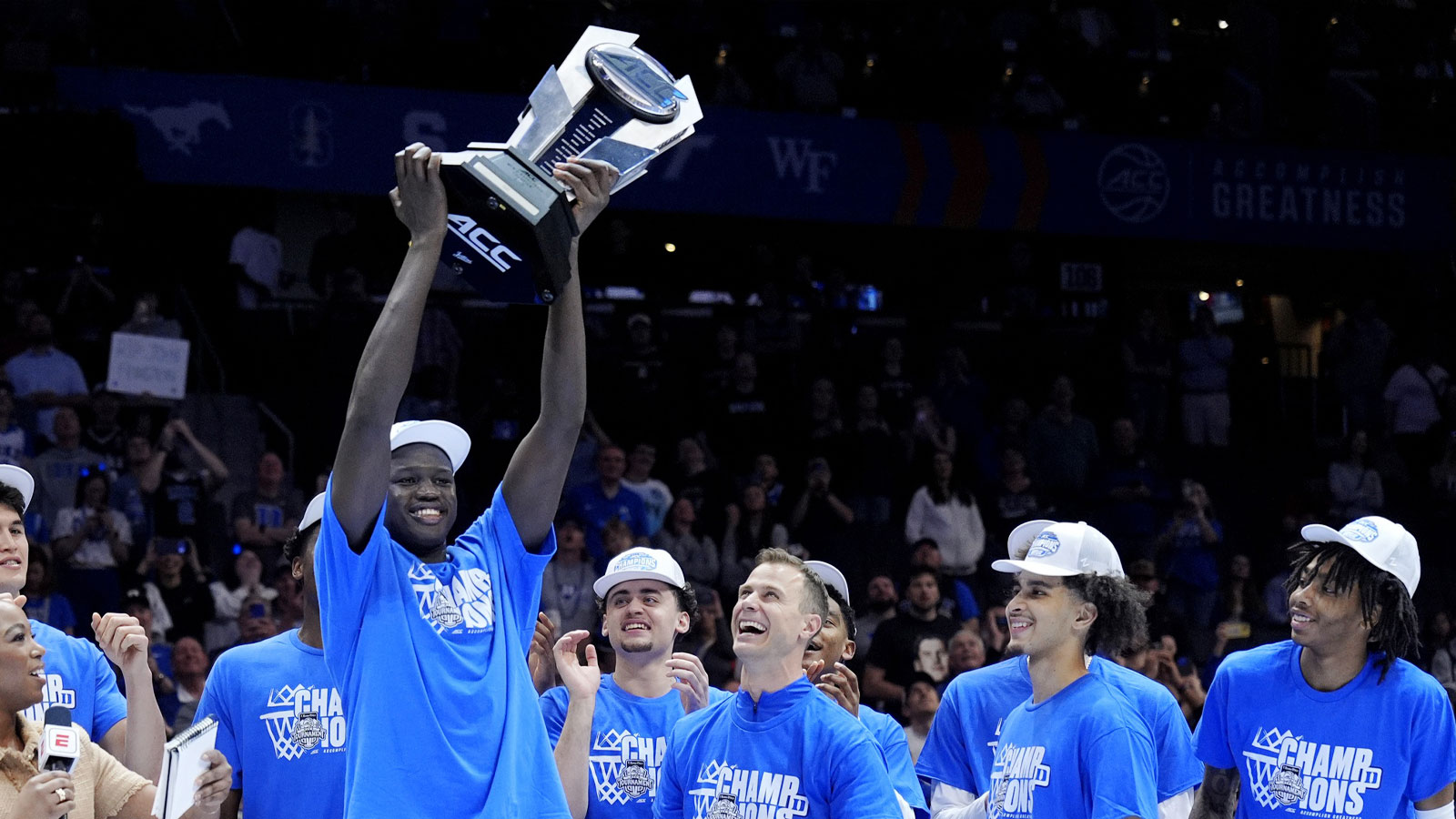 Duke Blue Devils center Khaman Maluach (9) holds the trophy and celebrates with head coach Jon Scheyer and teammates after winning the 2025 ACC Conference Championship game against the Louisville Cardinals at Spectrum Center.