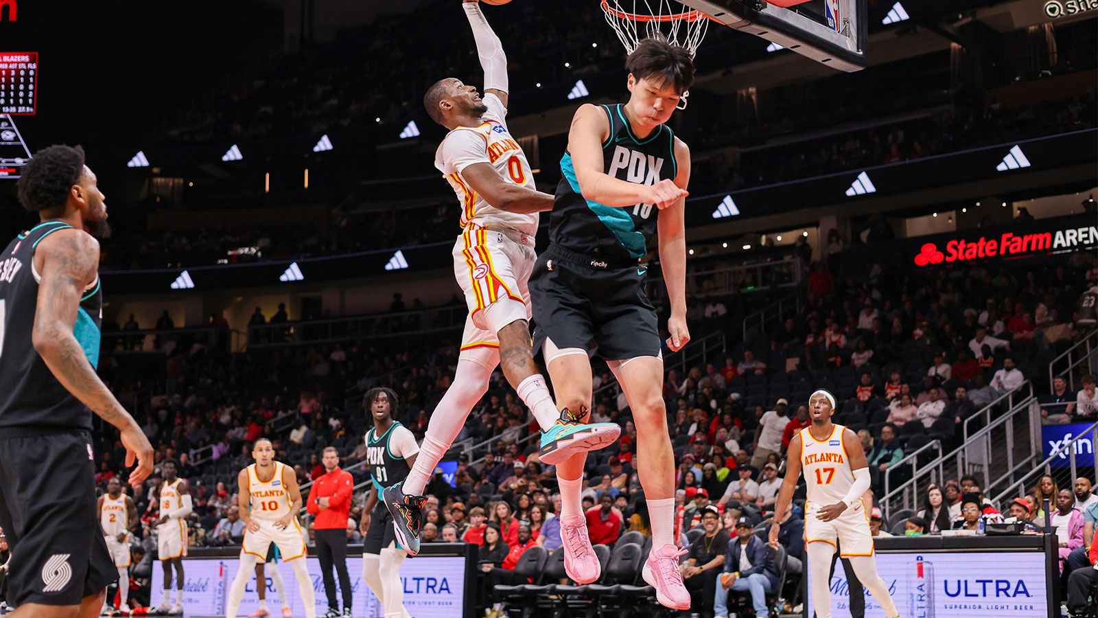 Atlanta Hawks forward Jonathan Kuminga (0) dunks over Portland Trail Blazers center Yang Hansen (16) in the fourth quarter at State Farm Arena.