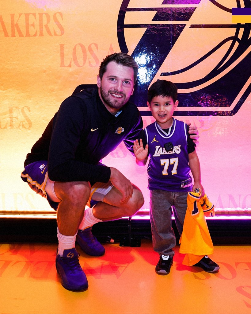Luka Dončić poses with a young fan.