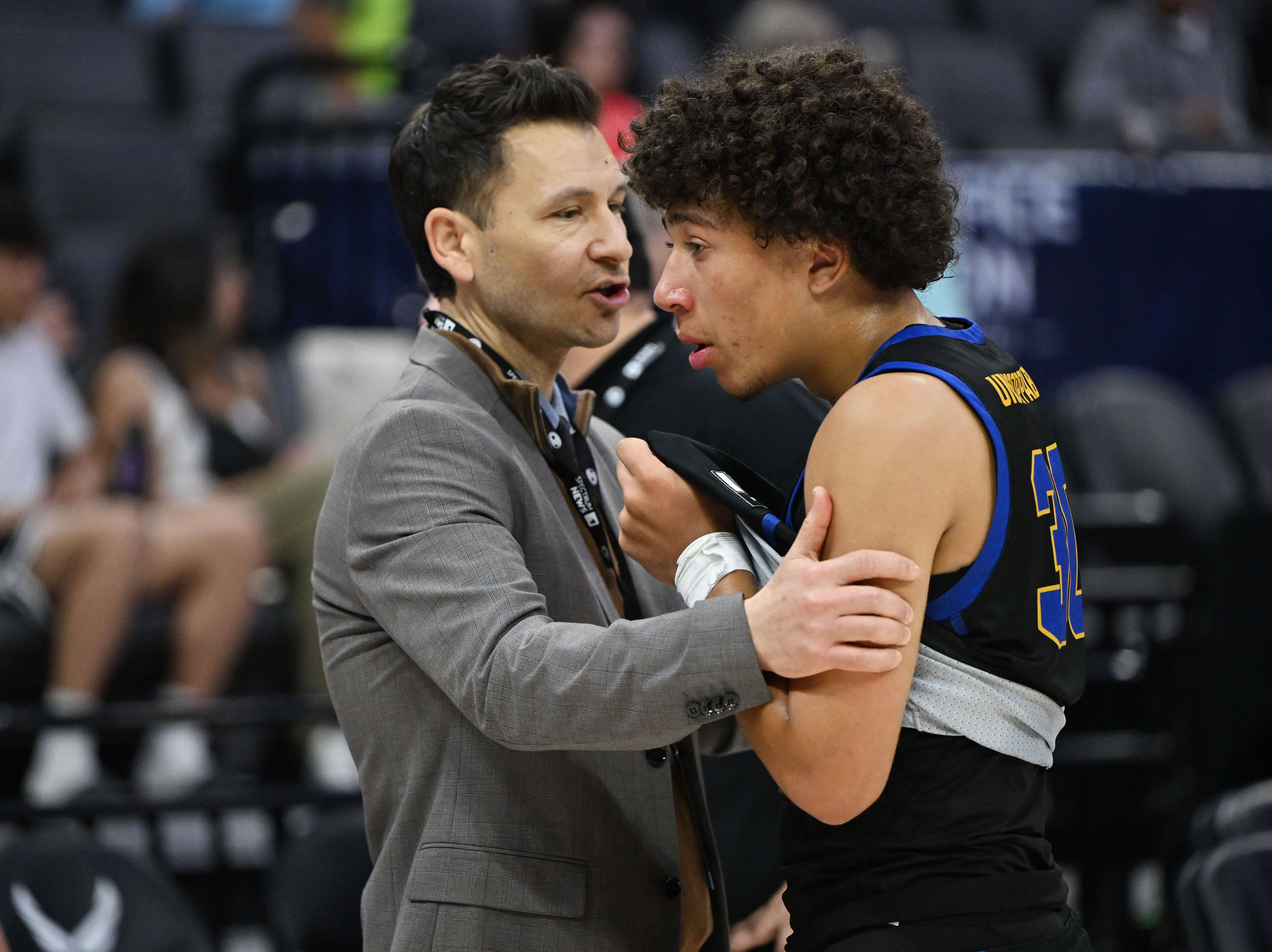 Kellen Owens #30 is consoled by head coach Jason Efstathiouof...