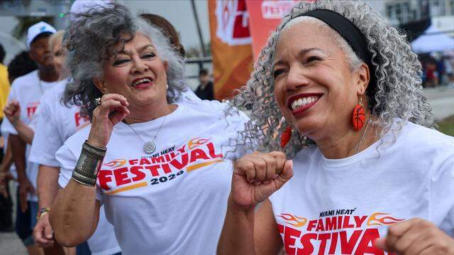 Heat Golden Oldies dancers Amalia Bauza, left, and Sharon Harvey Rosenberg, dance with energy as they greet attendees at the entrance of 26th Annual Miami Heat Family Festival.