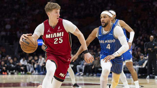 Miami Heat guard Kasparas Jakucionis (25) drives the ball as Orlando Magic guard Jalen Suggs (4) defends in the first half of their NBA game at Kaseya Center on Jan. 28, 2026, in Miami.