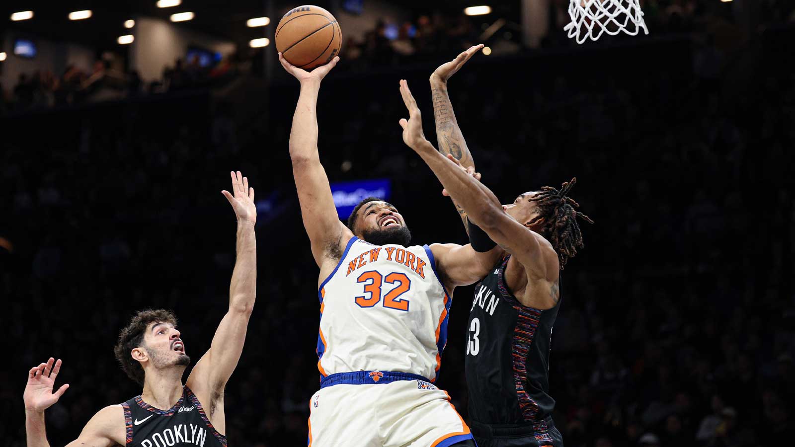New York Knicks center Karl-Anthony Towns (32) goes to the basket as Brooklyn Nets center Nic Claxton (33) and guard Ben Saraf (77) defend during the first half at Barclays Center. Mandatory Credit: Vincent Carchietta-Imagn Images