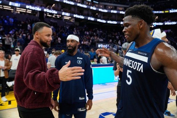 Minnesota Timberwolves guard Anthony Edwards (5) and Golden State Warriors' Stephen Curry, left, shake hands after an NBA basketball game Friday, March 13, 2026, in San Francisco. (AP Photo/Godofredo A. VÃ¡squez)