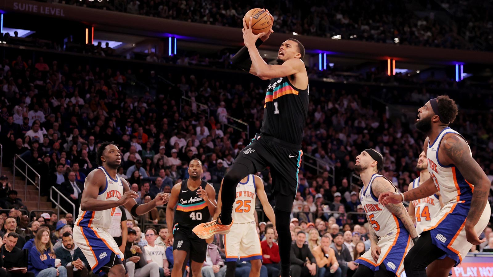 Spurs forward Victor Wembanyama (1) drives to the basket against New York Knicks forward OG Anunoby (8) and guards Mikal Bridges (25) and Jose Alvarado (5) and Landry Shamet (44) and center Mitchell Robinson (23) during the third quarter at Madison Square Garden