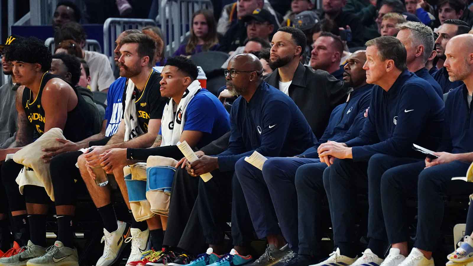 Golden State Warriors assistant coach Kris Weems watches the action while sitting between guard Stephen Curry (30) and assistant coach Jerry Stackhouse in the second quarter against the Denver Nuggets at Chase Center.