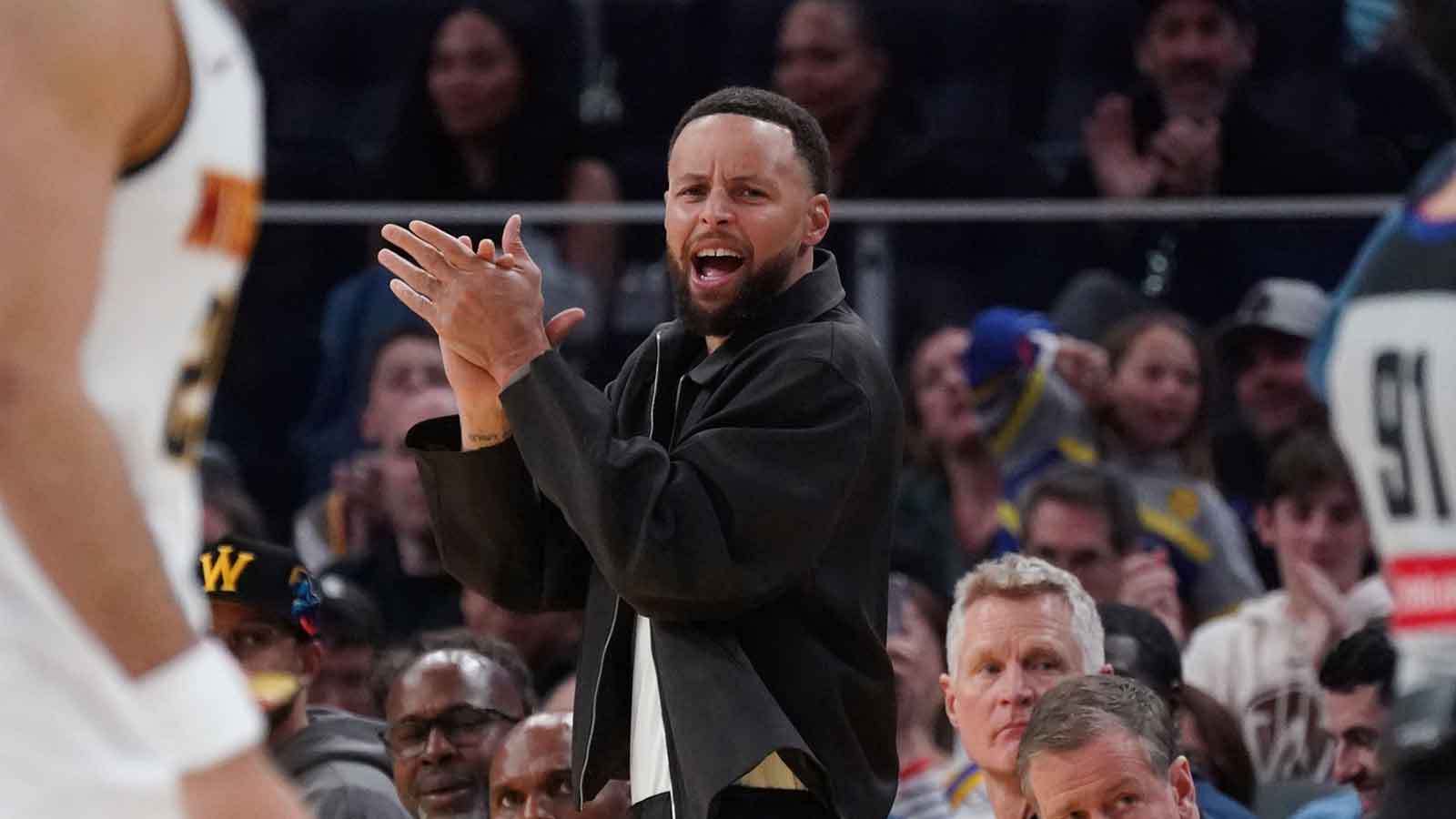 Golden State Warriors guard Stephen Curry (30) cheers from the bench during a game against the Denver Nuggets in the third quarter at Chase Center.
