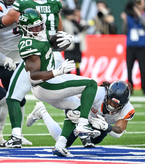 Talanoa Hufanga (9) of the Denver Broncos misses a tackle on Breece Hall (20) of the New York Jets during the third quarter at Tottenham Hotspur Stadium in London on Sunday, Oct. 12, 2025. (Photo by AAron Ontiveroz/The Denver Post)