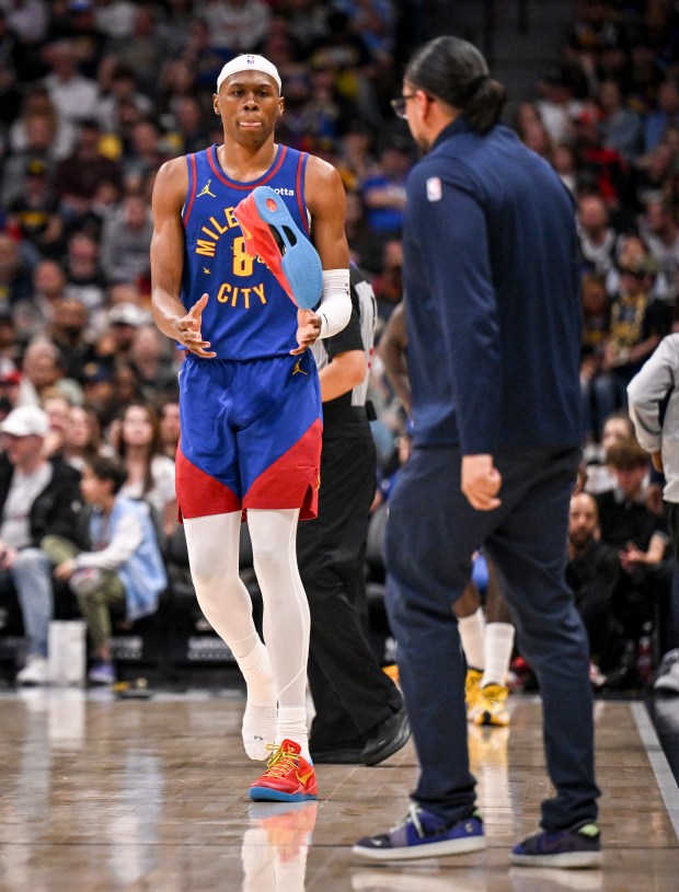 Assistant equipment manager Gene Marquez of the Denver Nuggets tosses a sneaker to Peyton Watson (8) after he lost it during the fourth quarter of the Nuggets' 128-112 win over the Portland Trail Blazers at Ball Arena in Denver on Sunday, March 22, 2026. (Photo by AAron Ontiveroz/The Denver Post)