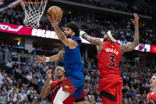 Guard Jamal Murray of the Denver Nuggets splits the defending forward Brandon Ingram (3) and forward/guard Scottie Barnes (4) of the Toronto Raptors during the second half of a 121-115 Nuggets win on Friday, March 20, 2026, at Ball Arena in Denver. (Photo by Timothy Hurst/The Denver Post)