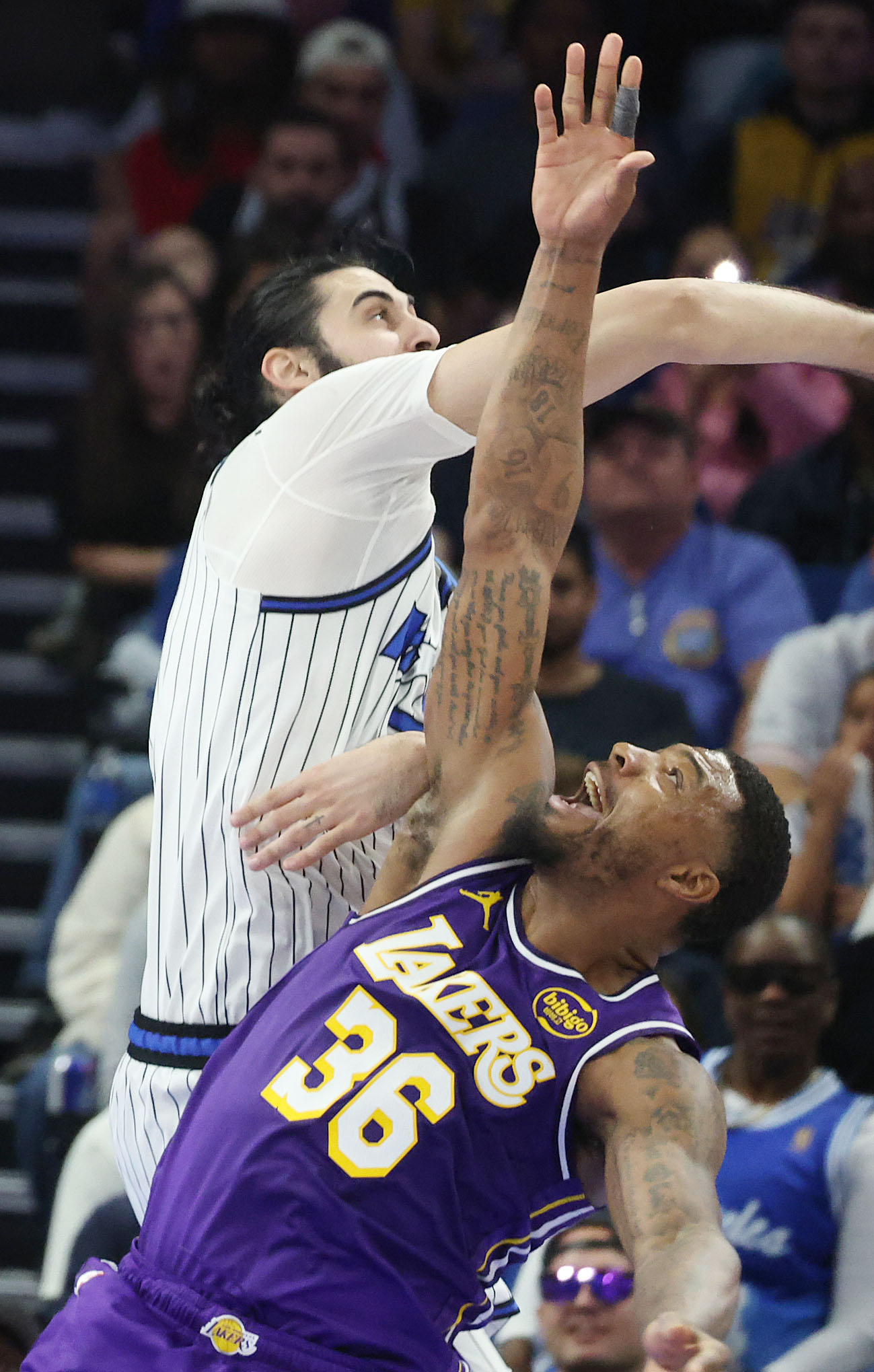 Orlando center Goga Bitadze (top) fouls LA forward Marcus Smart...