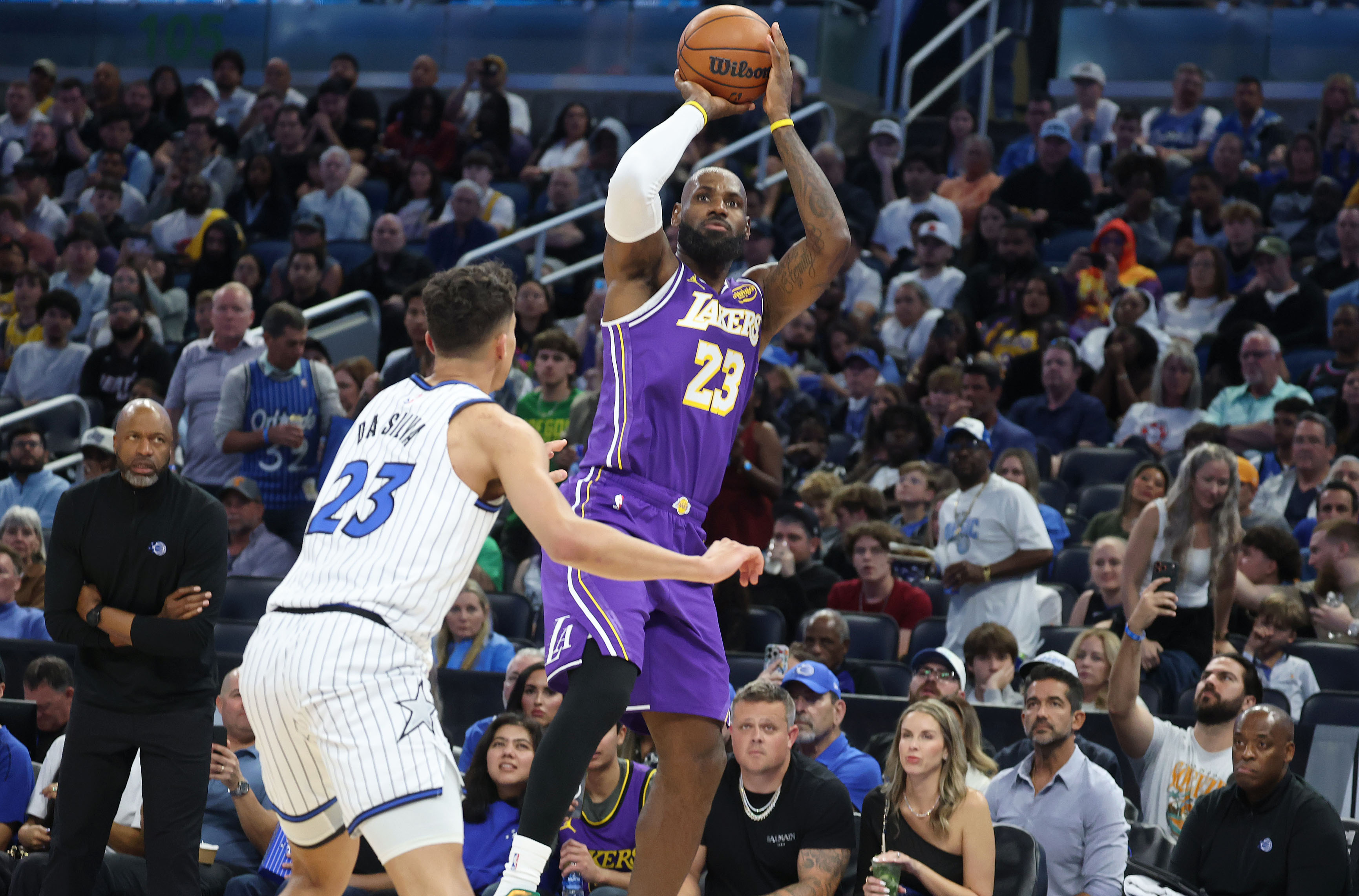 LA forward LeBron James (top) shoots over Orlando forward Tristan...