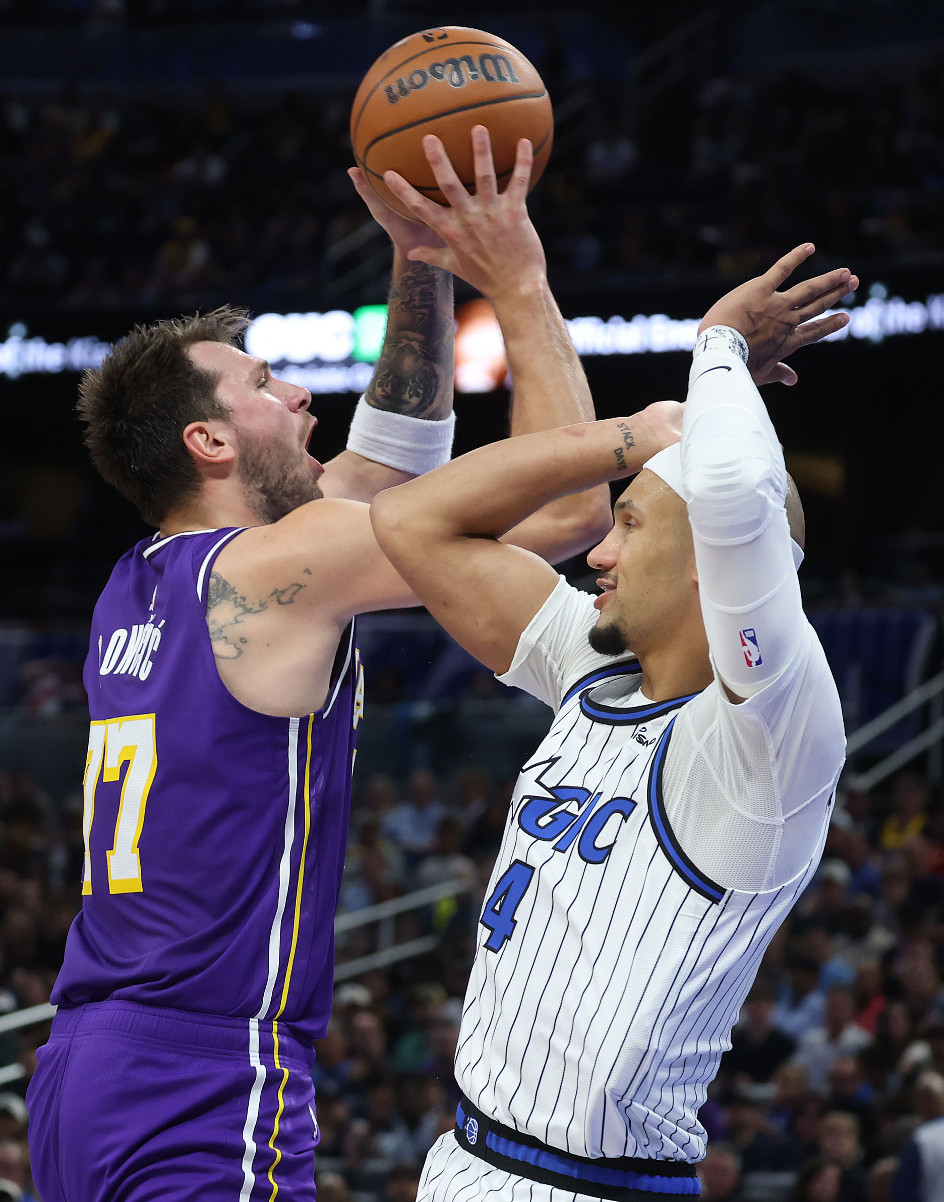 Orlando guard Luka Doncic (77) shoots over Orlando guard Jalen...