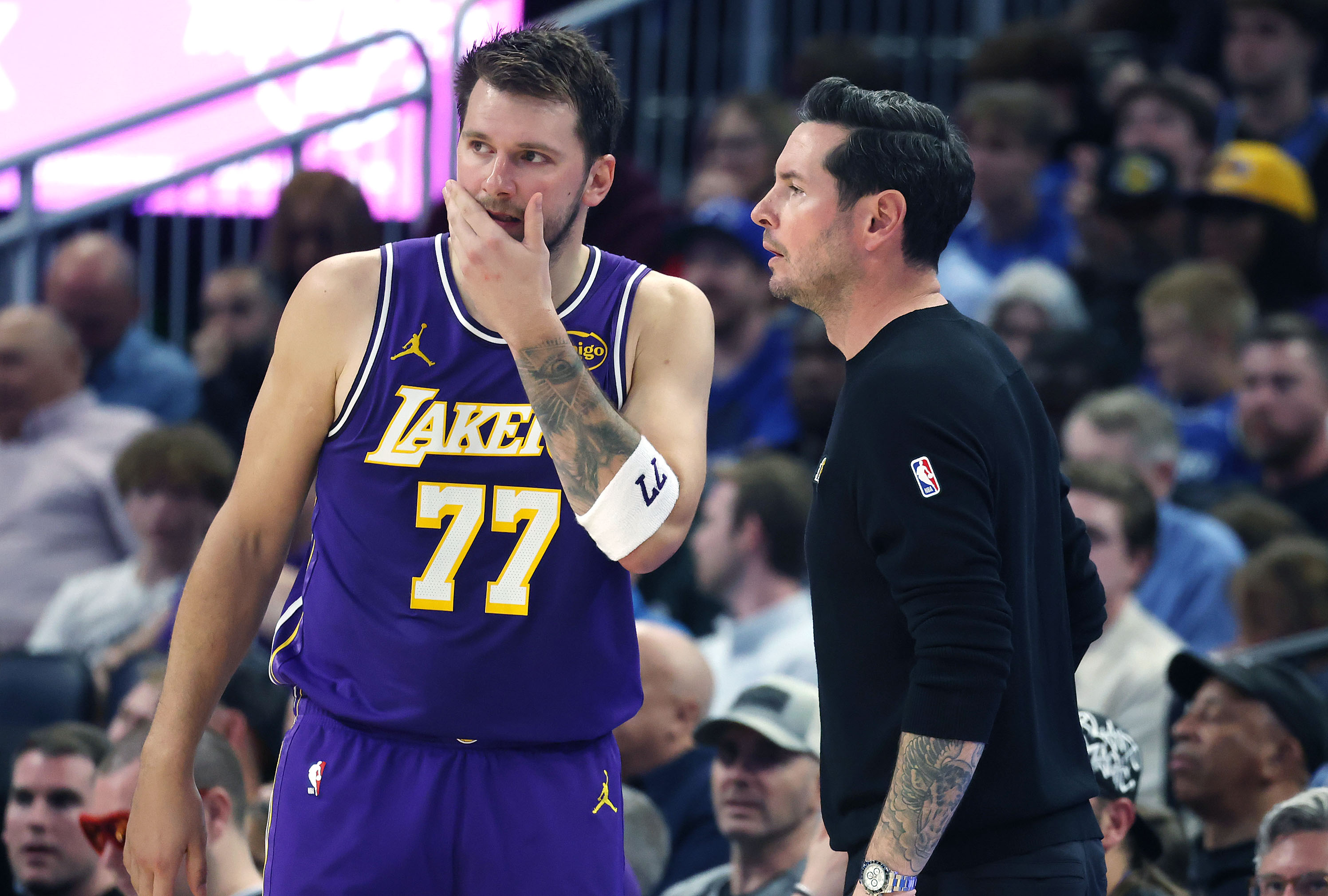 LA coach JJ Redick talks to guard Luka Doncic (77)...