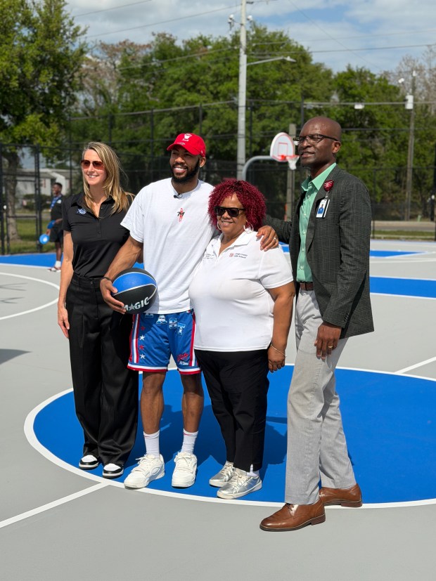 From left to right, Magic EVP of marketing and social responsibility Shelly Wilkes, Magic guard Jevon Carter, OCPS board member Vicki-Elaine Felder and AdventHealth East Orlando COO Paul Adeogun help unveil a newly refurbished outdoor basketball court at Oak Ridge High School on Wednesday. (Jason Beede/Orlando Sentinel)