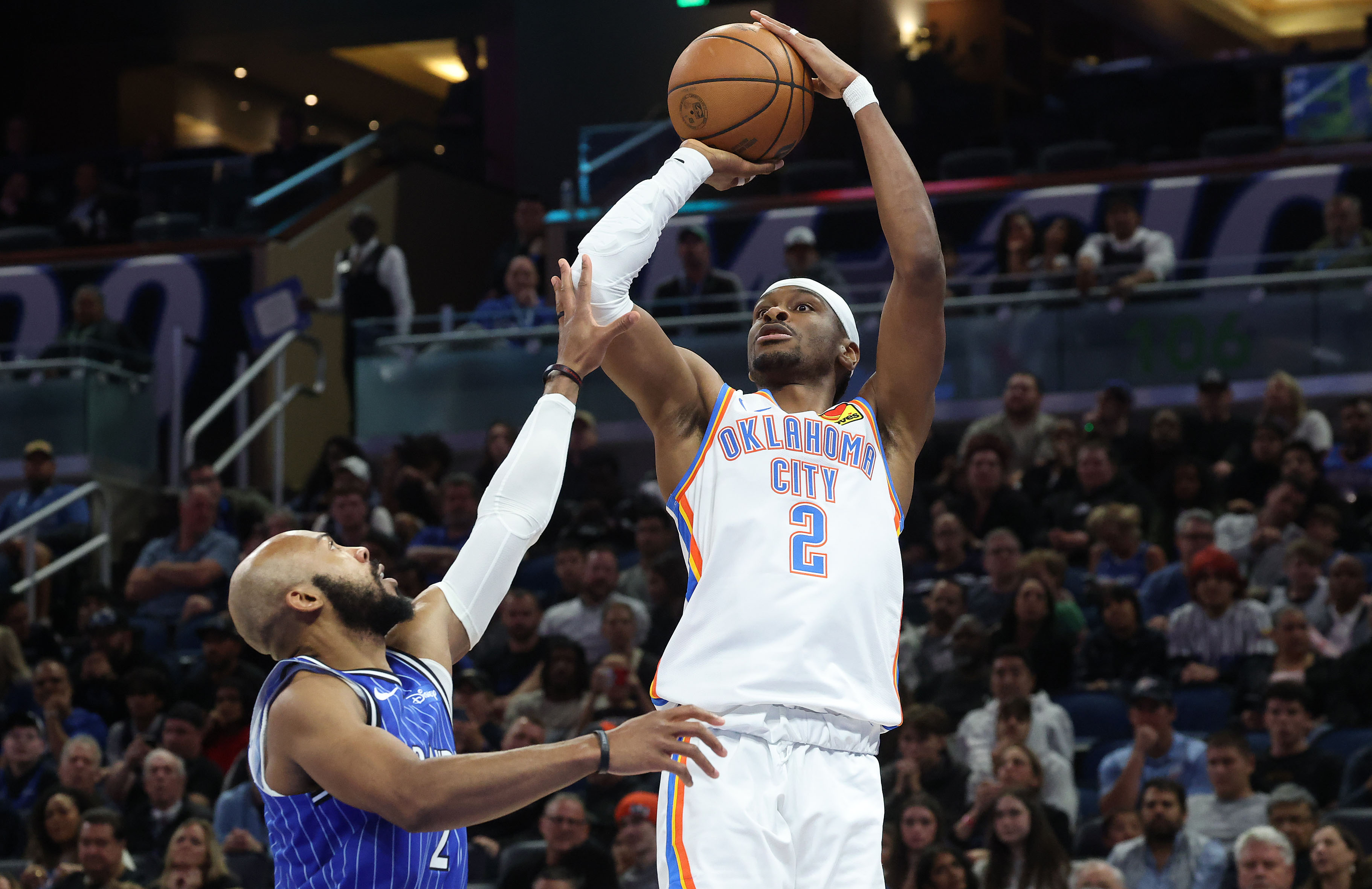 Thunder guard Shai Gilgeous-Alexander (top) shoots over Orlando guard Jevon...