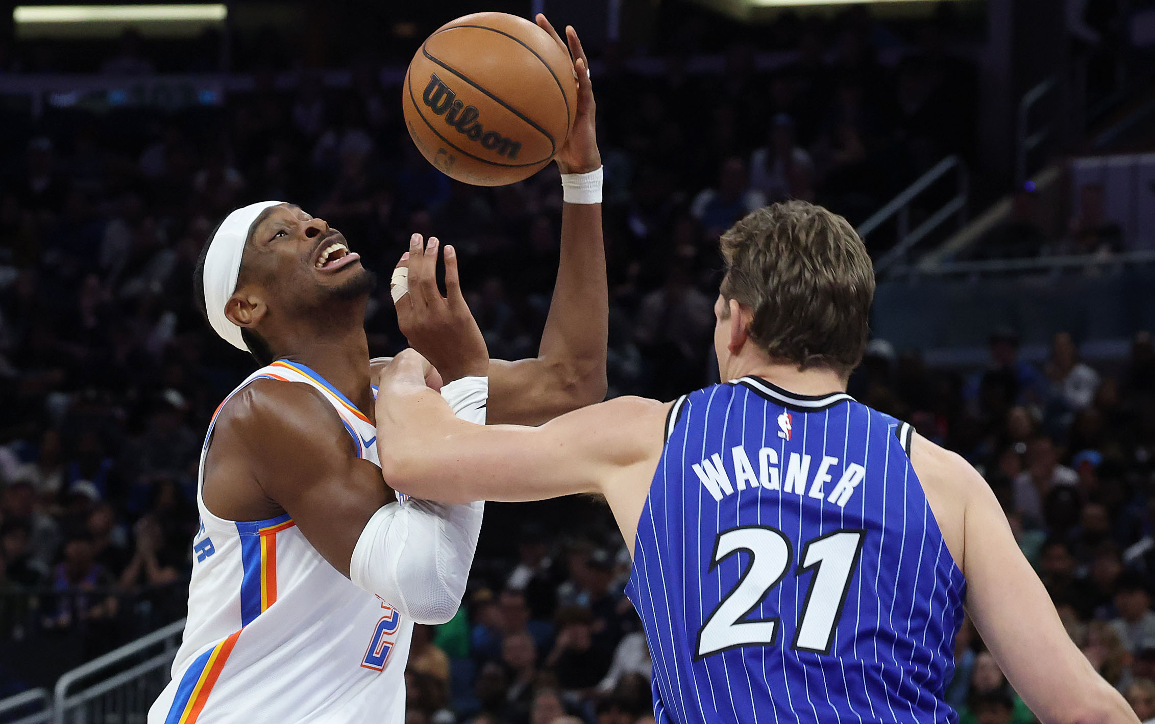 Magic center Mo Wagner (21) fouls Thunder guard Shai Gilgeous-Alexander...