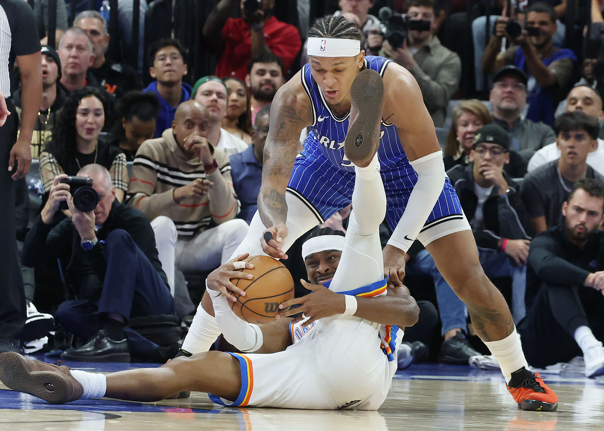 Orlando forward Paolo Banchero (top) tries to get the ball...