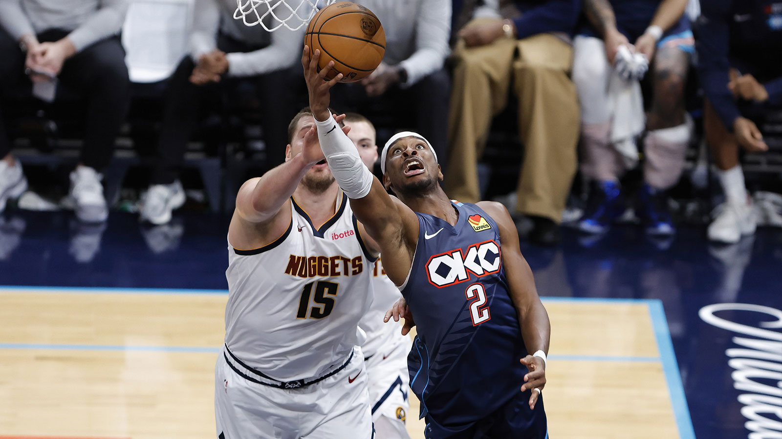 Thunder guard Shai Gilgeous-Alexander (2) goes up for a basket in front of Denver Nuggets center Nikola Jokić (15) during the fourth quarter at Paycom Center