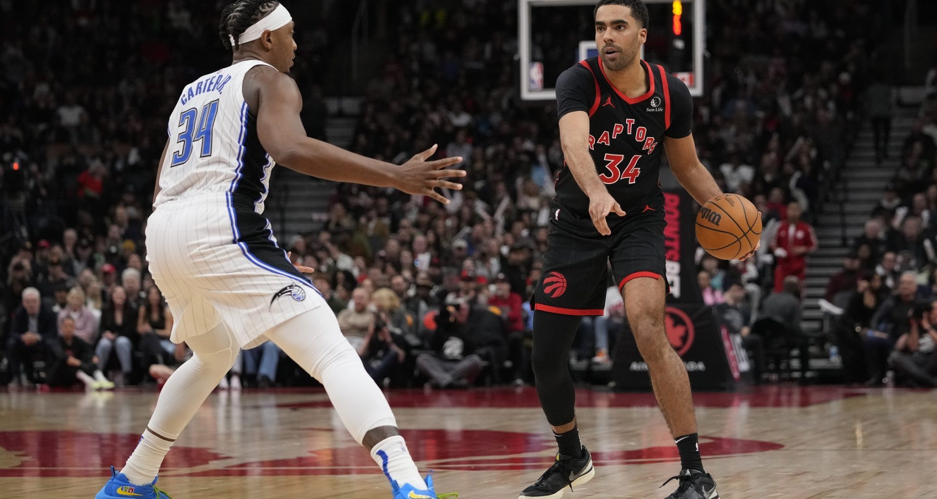 Mar 15, 2024; Toronto, Ontario, CAN; Toronto Raptors forward Jontay Porter (34) points to a spot as he controls the ball against Orlando Magic center Wendell Carter Jr. (34) during the second half at Scotiabank Arena.
