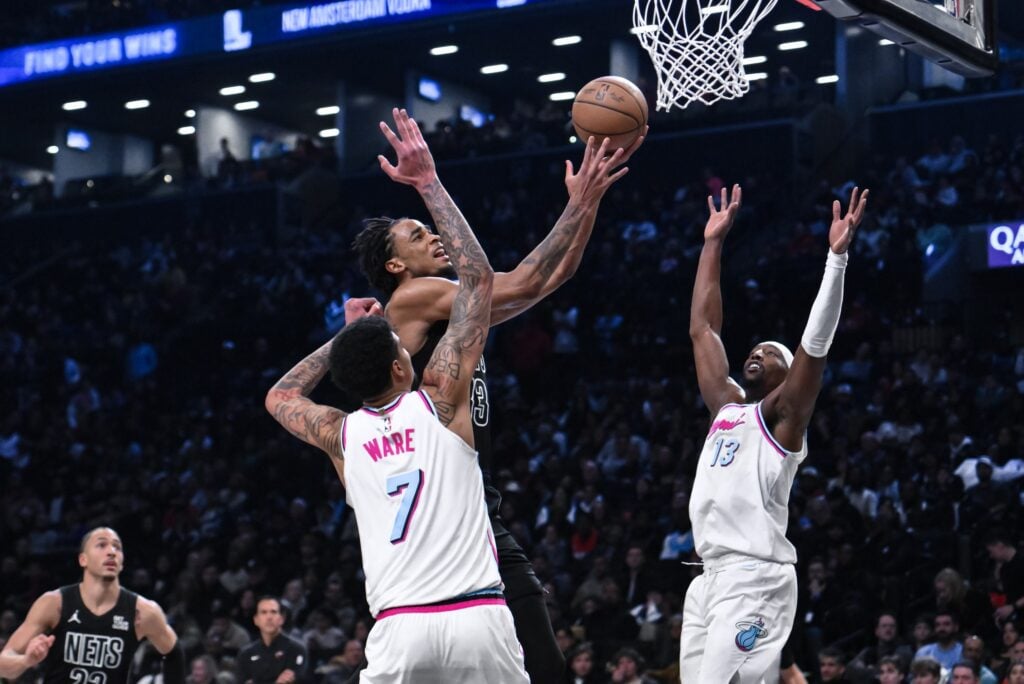 Jan 25, 2025; Brooklyn, New York, USA; Brooklyn Nets center Nic Claxton (33) drives to the basket against Miami Heat center Kel'el Ware (7) and center Bam Adebayo (13) during the second half at Barclays Center. Mandatory Credit: John Jones-Imagn Images