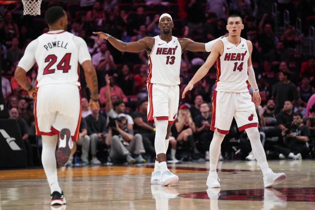 Miami Heat forward-center Bam Adebayo in the middle of guards Norman Powell and Tyler Herro, directing the defense