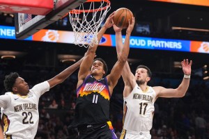 Mar 6, 2026; Phoenix, Arizona, USA; Phoenix Suns forward Oso Ighodaro (11) dunks over New Orleans Pelicans center Derik Queen (22) and New Orleans Pelicans forward Karlo Matkovic (17) during the first half at Mortgage Matchup Center. Mandatory Credit: Joe Camporeale-Imagn Images