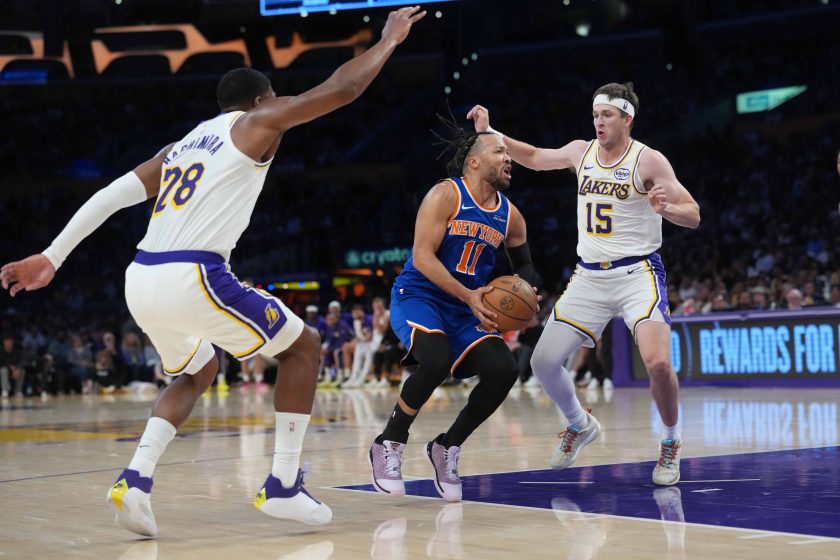 Mar 8, 2026; Los Angeles, California, USA; New York Knicks guard Jalen Brunson (11) is defended by Los Angeles Lakers forward Rui Hachimura (28) and guard Austin Reaves (15) in the first half at Crypto.com Arena.