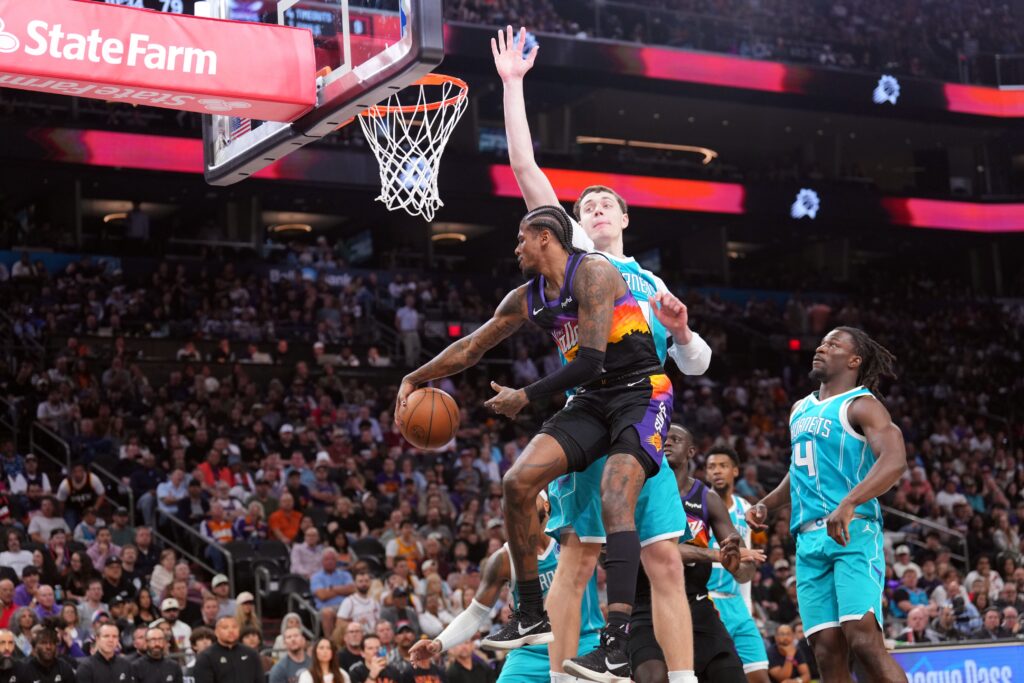 Mar 8, 2026; Phoenix, Arizona, USA; Phoenix Suns guard Jalen Green (4) passes the ball by Charlotte Hornets center Ryan Kalkbrenner (11) during the second half at Mortgage Matchup Center. Mandatory Credit: Joe Camporeale-Imagn Images