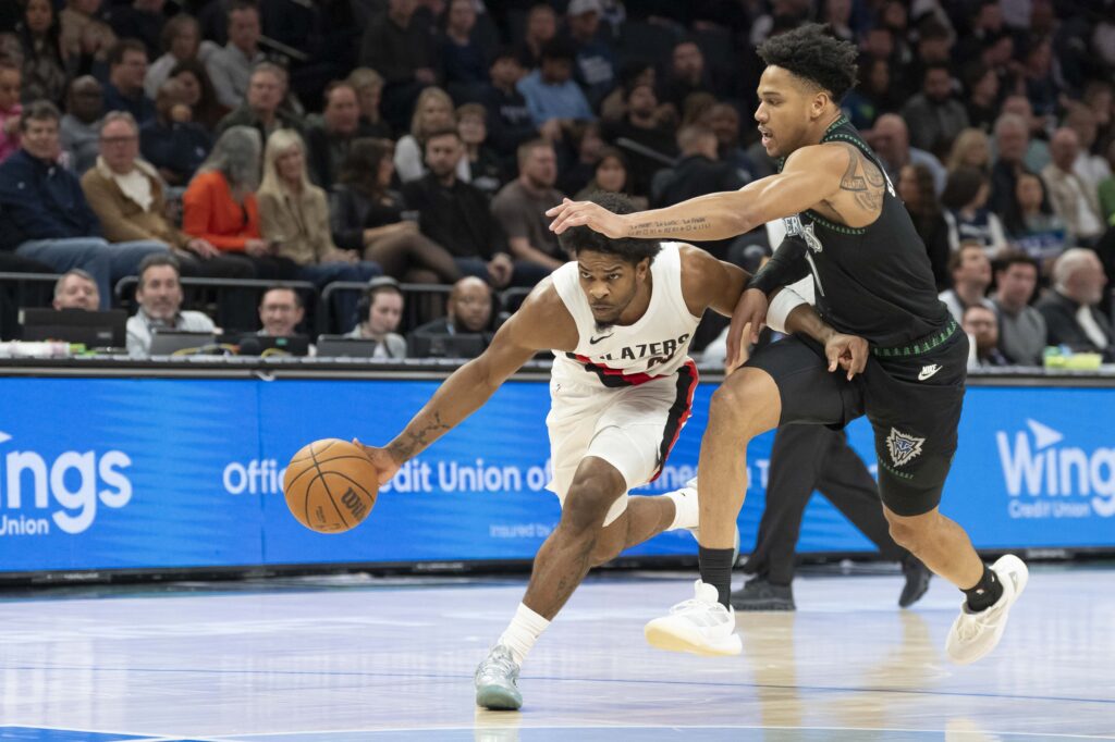 Portland Trail Blazers guard Scoot Henderson (00) dribbles the ball as Minnesota Timberwolves guard Terrence Shannon Jr. (1) plays defense in the first half at Target Center.