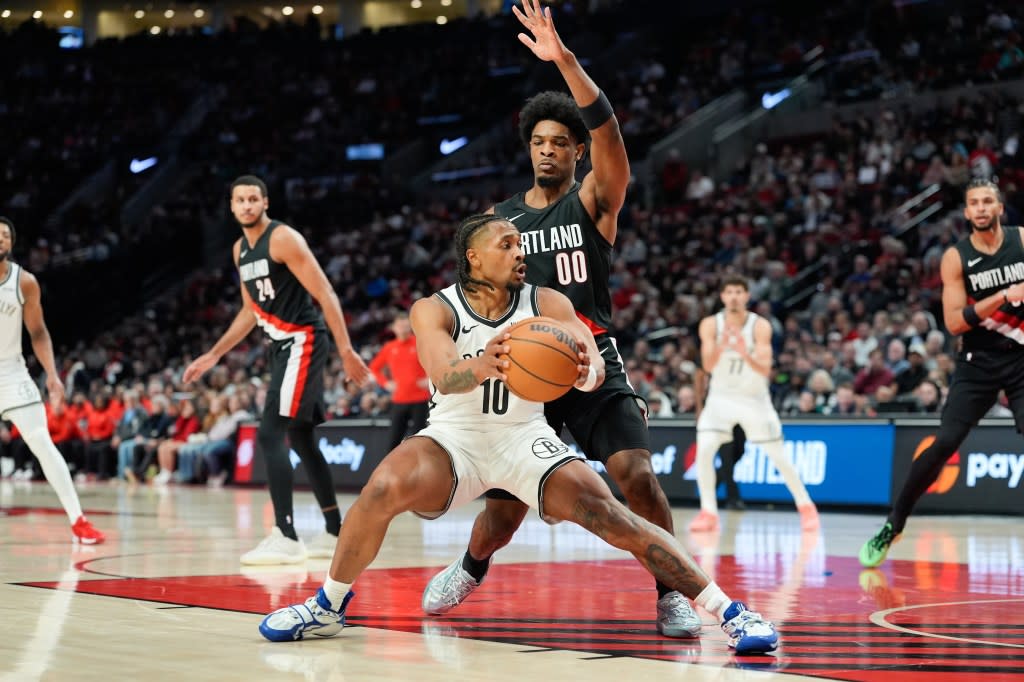 Nets guard Tyson Etienne (10) looks to get around Portland Trail Blazers guard Scoot Henderson (00) during the first half of an NBA basketball game Monday, March 23, 2026, in Portland, Ore. AP