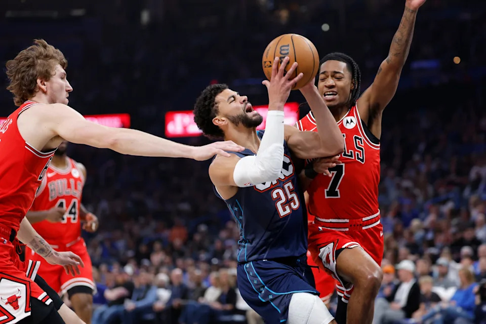 Mar 27, 2026; Oklahoma City, Oklahoma, USA; Oklahoma City Thunder guard Ajay Mitchell (25) drives between Chicago Bulls forward Matas Buzelis (14) and guard Rob Dillingham (7) during the first quarter at Paycom Center. Mandatory Credit: Alonzo Adams-Imagn Images