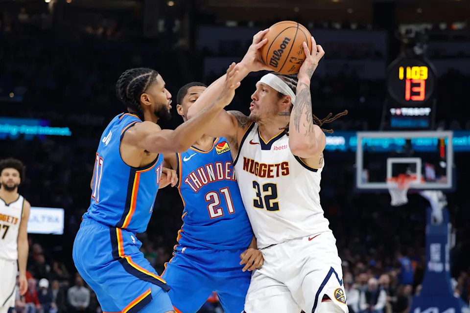 Mar 9, 2026; Oklahoma City, Oklahoma, USA; Denver Nuggets forward Aaron Gordon (32) drives between Oklahoma City Thunder guard Isaiah Joe (11) and guard Aaron Wiggins (21) during the second quarter at Paycom Center. Mandatory Credit: Alonzo Adams-Imagn Images