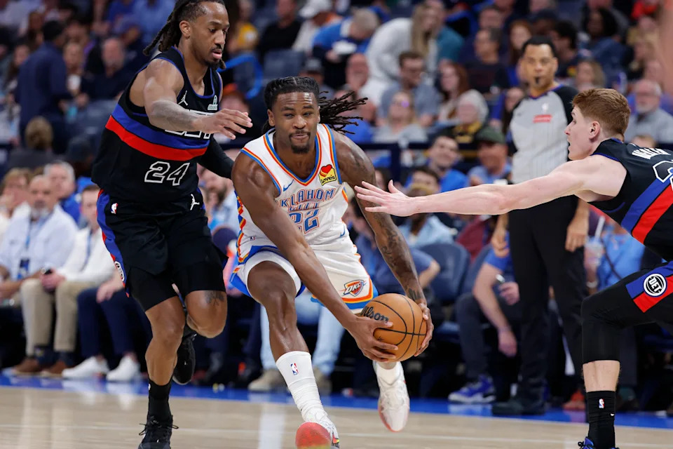 Mar 30, 2026; Oklahoma City, Oklahoma, USA; Oklahoma City Thunder guard Cason Wallace (22) drives between Detroit Pistons guard Daniss Jenkins (24) and guard Kevin Huerter (27) during the second half at Paycom Center. Mandatory Credit: Alonzo Adams-Imagn Images