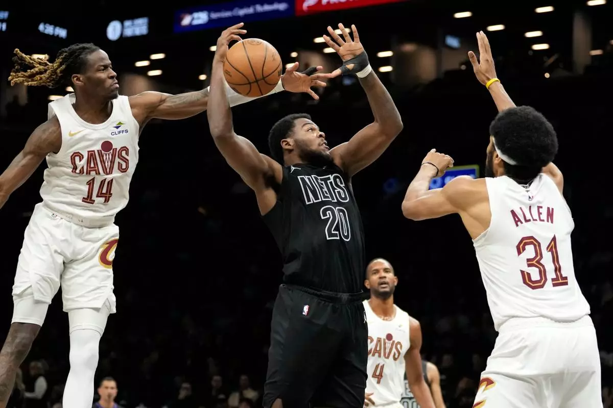 Cleveland Cavaliers guard Keon Ellis (14) blocks Brooklyn Nets center Day'ron Sharpe (20) during the first half of an NBA basketball game, Sunday, March 1, 2026, in New York. (AP Photo/Yuki Iwamura)