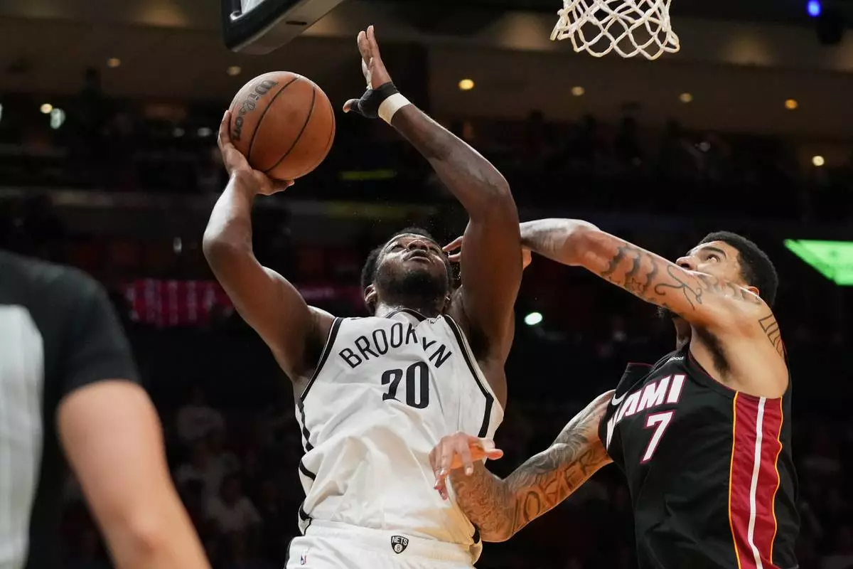 Brooklyn Nets center Day'ron Sharpe (20) shoots as Miami Heat center Kel'el Ware (7) defends during the first half of an NBA basketball game, Tuesday, March 3, 2026, in Miami. (AP Photo/Lynne Sladky)