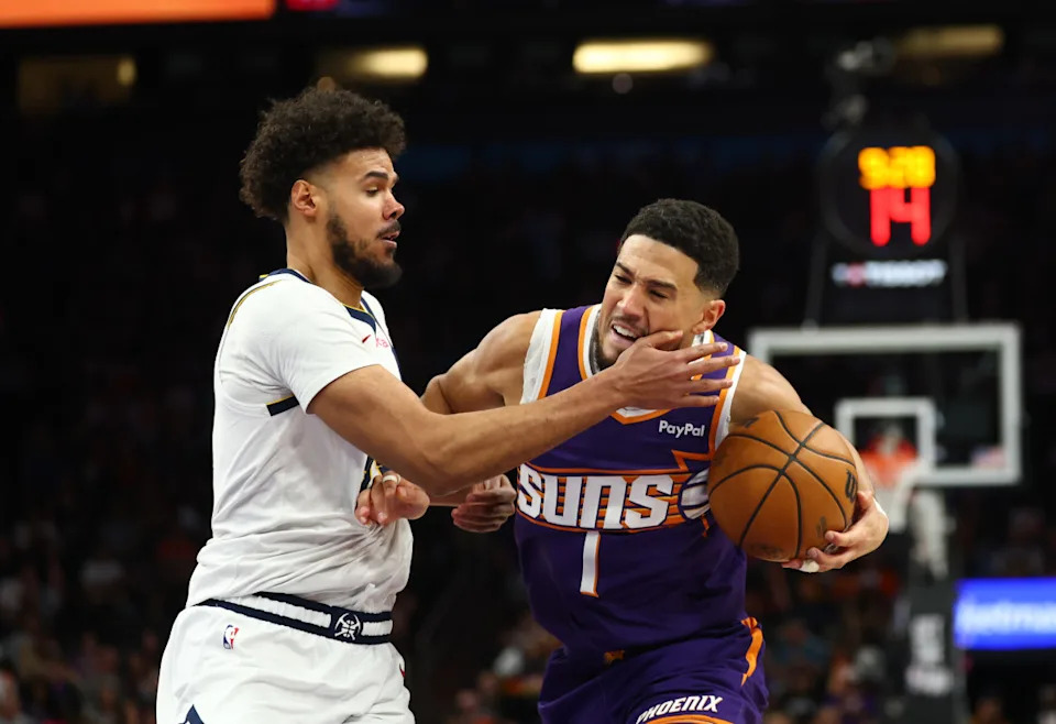 Phoenix Suns guard Devin Booker (1) against Denver Nuggets forward Cameron Johnson (23) in the second half at Mortgage Matchup Center.Mark J&period; Rebilas-Imagn Images