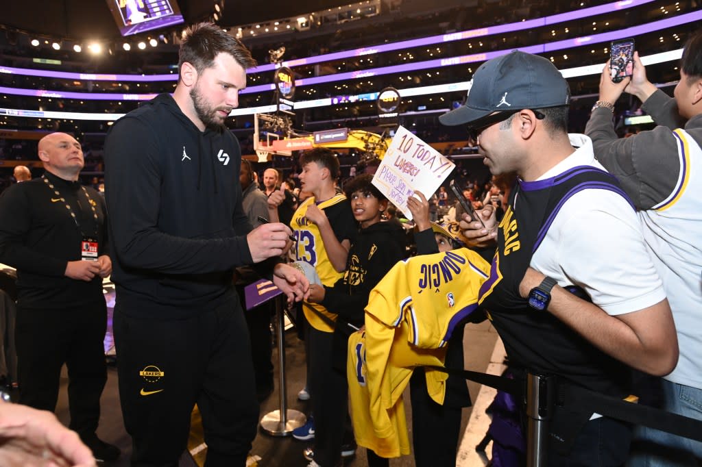 Luka Doncic signing memorabilia for a fan before the Lakers’ game against the Timberwolves. NBAE via Getty Images