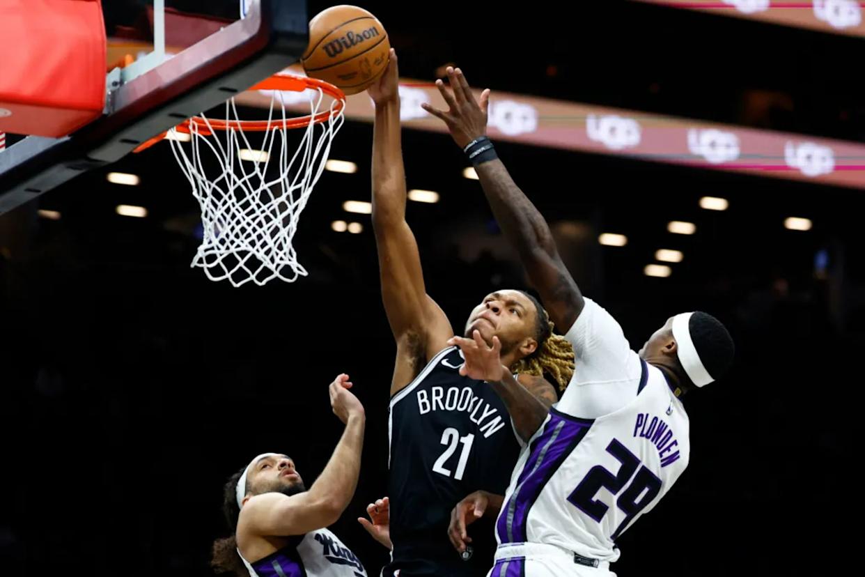 An image collage containing 1 images, Image 1 shows Brooklyn Nets player Noah Clowney (21) shooting over Sacramento Kings players Devin Carter (22) and Daeqwon Plowden (29)
