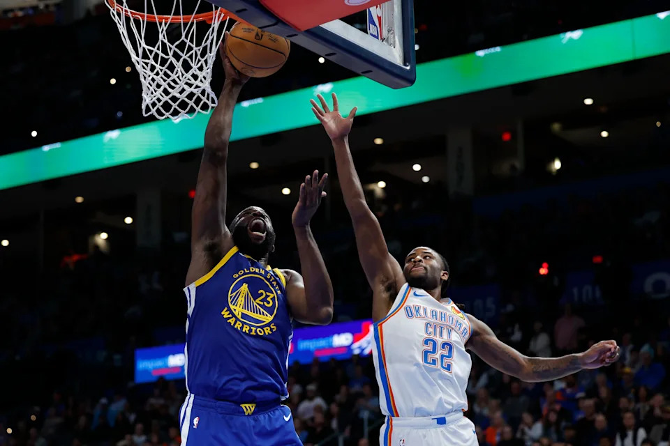 Mar 7, 2026; Oklahoma City, Oklahoma, USA; Golden State Warriors forward Draymond Green (23) goes up for a basket beside Oklahoma City Thunder guard Cason Wallace (22) during the second half at Paycom Center. Mandatory Credit: Alonzo Adams-Imagn Images