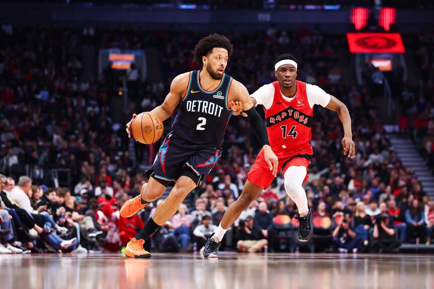 Cade Cunningham of the Detroit Pistons drives against Ja'Kobe Walter of the Toronto Raptors during the first half of their NBA game.