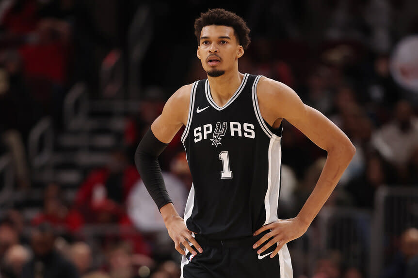 Victor Wembanyama on the court with his hands on his hips