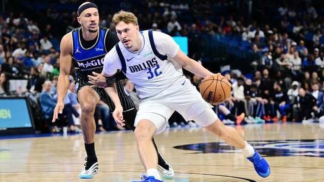 Cooper Flagg (#32) of the Dallas Mavericks drives to the basket against Jalen Suggs of the Orlando Magic in the first half of a game at Kia Center on March 5, 2026 in Orlando, Florida.