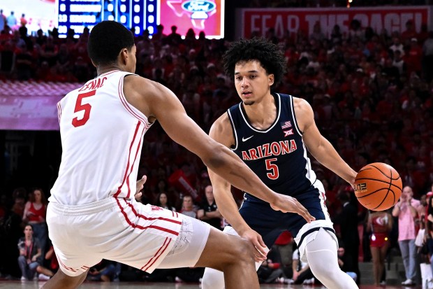 Arizona guard Brayden Burries dribbles the ball as Houston forward Chris Cenac Jr. defends during a game, Saturday, Feb. 21, 2026, in Houston. (AP Photo/Maria Lysaker)