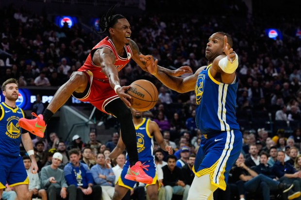 Chicago Bulls guard Rob Dillingham, left, passes the ball while defended by Golden State Warriors center Al Horford (20) during the second half of an NBA basketball game, Tuesday, March 10, 2026, in San Francisco. (AP Photo/Godofredo A. Vásquez)