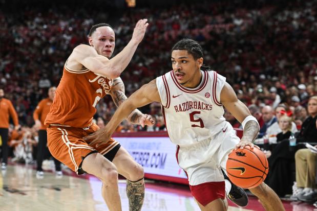 Arkansas guard Darius Acuff Jr. drives past Texas guard Chendall Weaver during a game Wednesday, March 4, 2026, in Fayetteville, Ark. (AP Photo/Michael Woods)