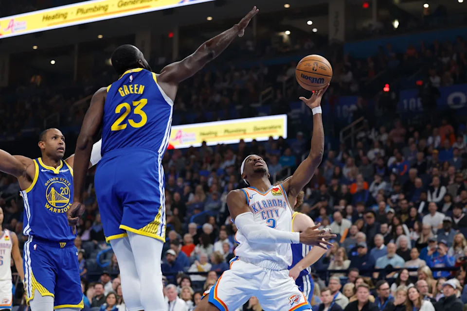Mar 7, 2026; Oklahoma City, Oklahoma, USA; Oklahoma City Thunder guard Shai Gilgeous-Alexander (2) shoots as Golden State Warriors forward Draymond Green (23) defends during the first half at Paycom Center. Mandatory Credit: Alonzo Adams-Imagn Images